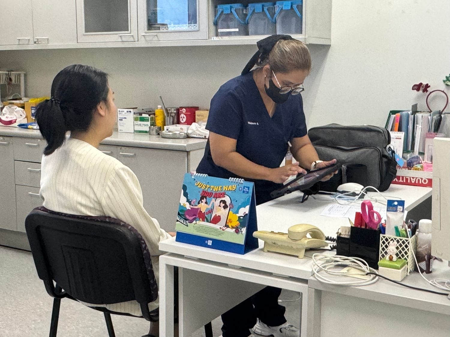 A W-Asia nurse attending to an employee at an on-site nursing station