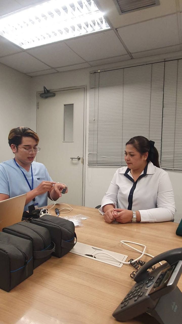 A W-Asia clinician fitting a portable home sleep-test device for a client